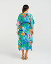 Woman wearing a colorful tropical dress with parrot pattern on a white background Sonya Dress Jungle