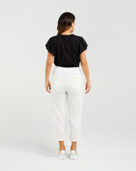 Woman wearing a black top and white pants on a plain background
Rhea Pants White