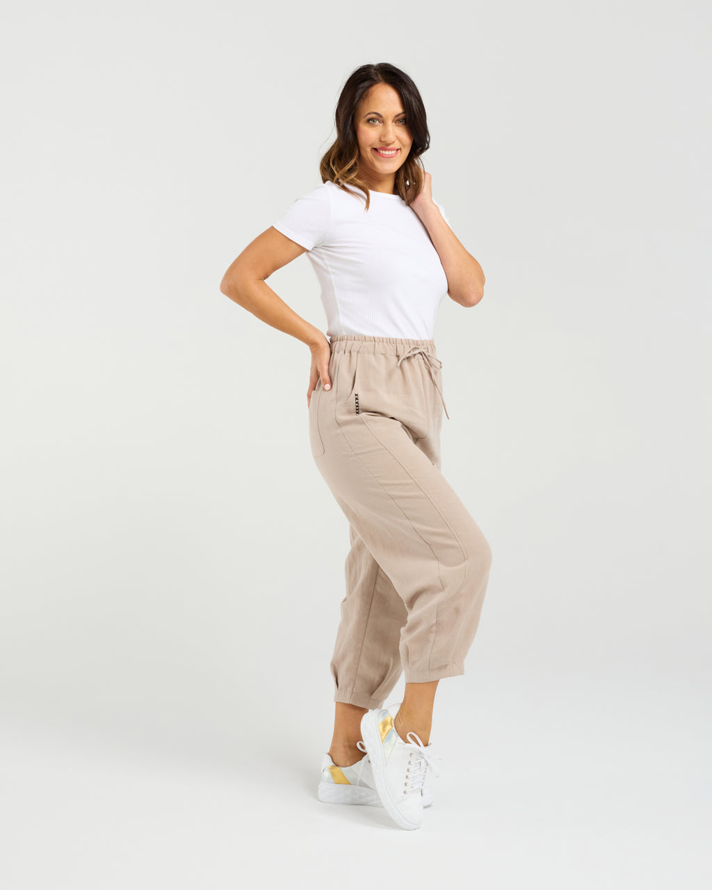 Woman wearing a white t-shirt and beige pants on a white background Nova Pants Natural
