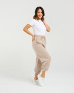 Woman wearing a white t-shirt and beige pants on a white background Nova Pants Natural