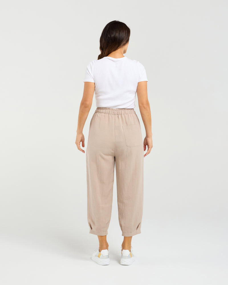 Woman wearing beige pants and a white shirt on a plain background Nova Pants Natural