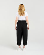Person wearing black pants and a white shirt on a plain background Nova Pants Black
