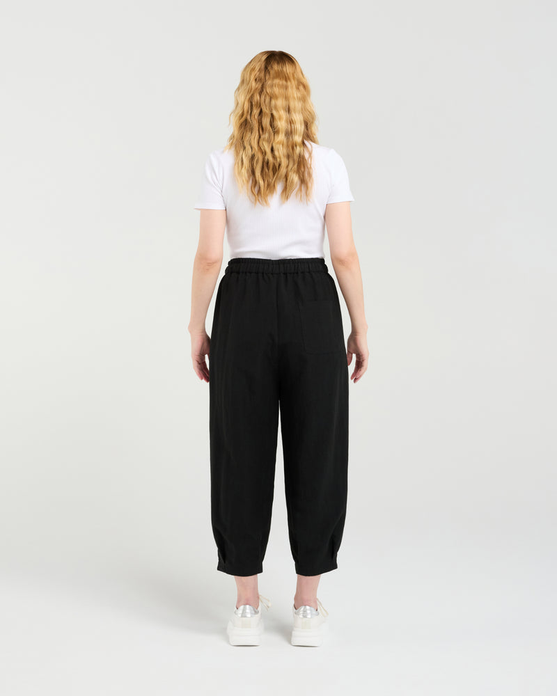 Person wearing black pants and a white shirt on a plain background Nova Pants Black