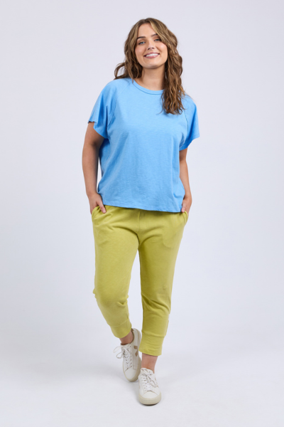 Woman wearing a blue top and green pants on a white background
Shelby Tee Azure Blue