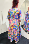 Person wearing a colorful butterfly-patterned dress in front of a mirror.
Sher Dress Purple