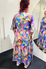 Person wearing a colorful butterfly-patterned dress in front of a mirror.
Sher Dress Purple