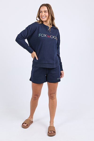 Woman wearing navy sweatshirt and shorts with 'FOXWOOD' branding on a white background
Simplified Confetti Crew Navy