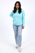 Woman wearing a light blue sweatshirt and light gray pants on a white background
Simplified Crew Light Blue