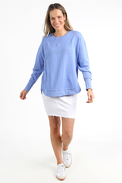 Woman wearing a light blue sweatshirt with a brand logo on a white background
Simplified Crew Neon Blue