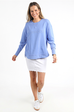 Woman wearing a light blue sweatshirt with a brand logo on a white background
Simplified Crew Neon Blue