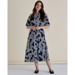 Woman wearing a patterned dress against a plain background