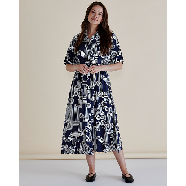 Woman wearing a patterned dress against a plain background