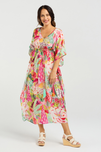 Woman wearing a colorful floral dress on a white background Sonya Dress Blossom Pop