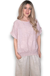 Woman wearing a light pink top and beige pants on a white background Split Back River Tee Baby Pink