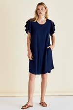 Woman wearing a navy blue dress with ruffled sleeves against a beige background
Sydney Tee Dress Navy