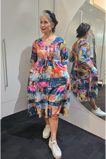 Woman wearing a colorful dress standing in front of a mirror. Tie Front Dress Turquoise