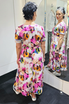 Woman trying on a colorful dress in front of a mirror.
V Neck Dress Pink