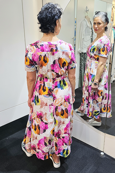 Woman trying on a colorful dress in front of a mirror.
V Neck Dress Pink