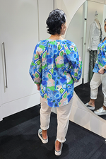 Person wearing a colorful patterned shirt in a store setting
V Neck Top Blue