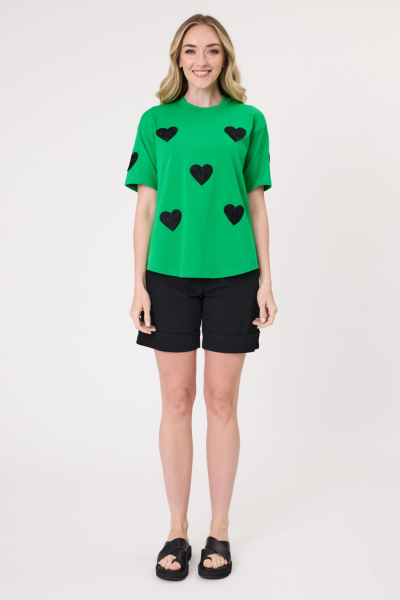 Woman wearing a green t-shirt with black heart patterns on a white background
Valentina Tee Green