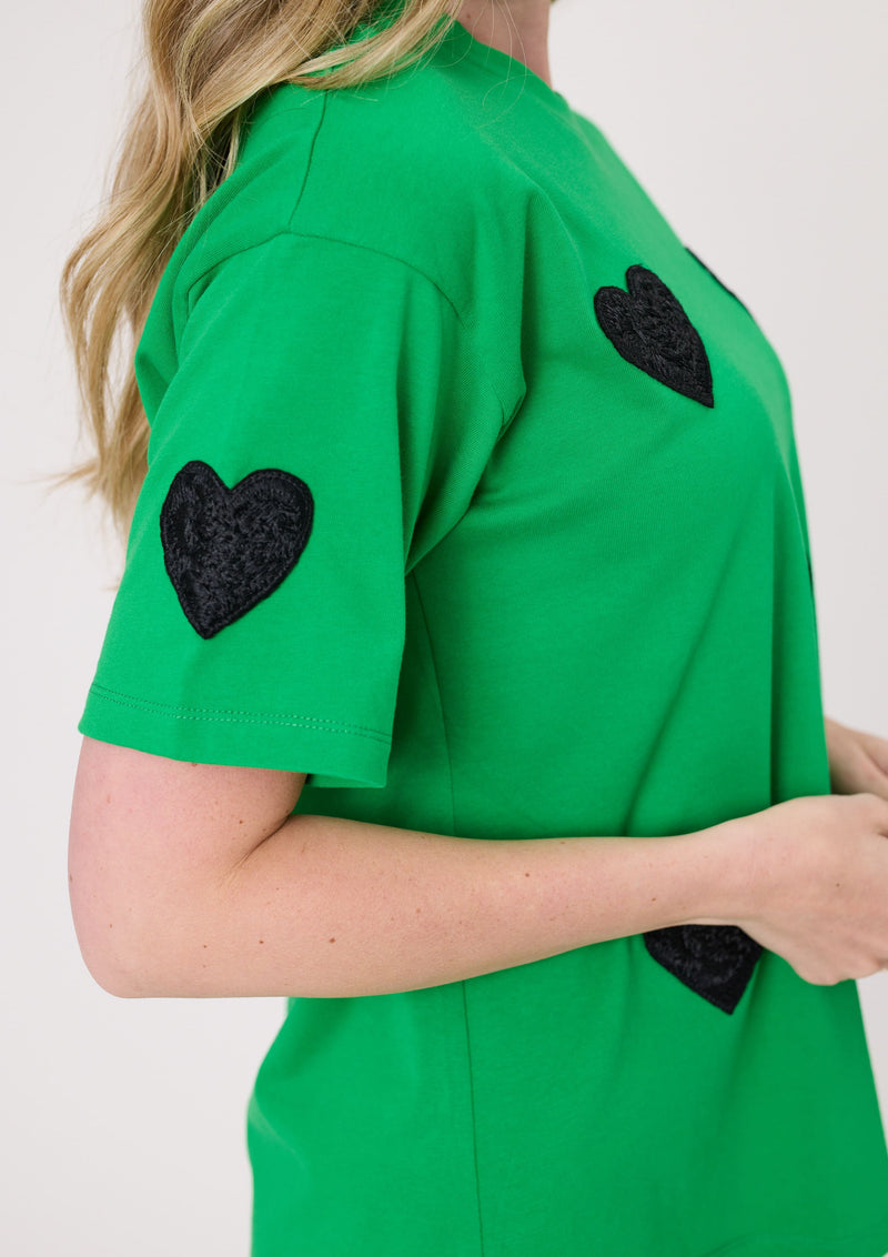 Green shirt with black heart-shaped patches on a plain background
Valentina Tee Green
