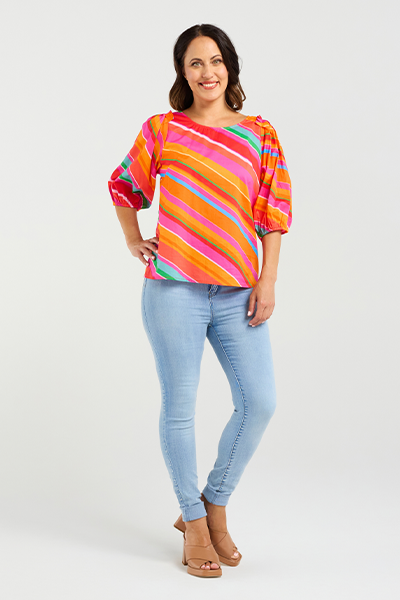 Woman wearing a colorful striped shirt and light blue jeans on a white background
Willow Top Dynamic Stripe