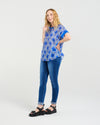 Woman wearing a blue patterned top and blue jeans on a white background
Olivia Top Paisley Painting