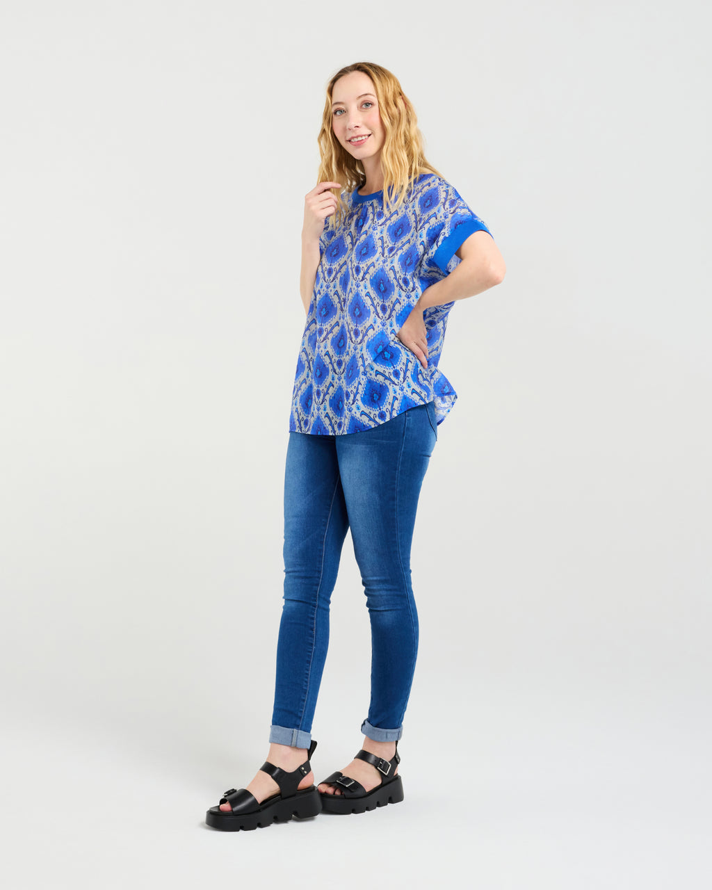 Woman wearing a blue patterned top and blue jeans on a white background
Olivia Top Paisley Painting
