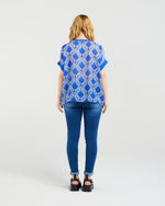 Person wearing a blue patterned top and jeans on a white background
Olivia Top Paisley Painting