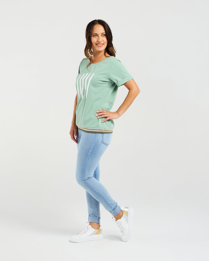 Woman wearing a green t-shirt and light blue jeans on a white background
Mia T-Shirt Mint