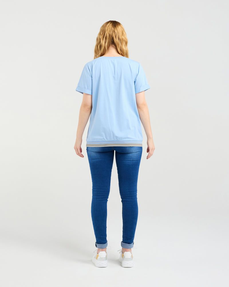 Person wearing a light blue t-shirt and blue jeans on a white background
Mia T-Shirt Blue