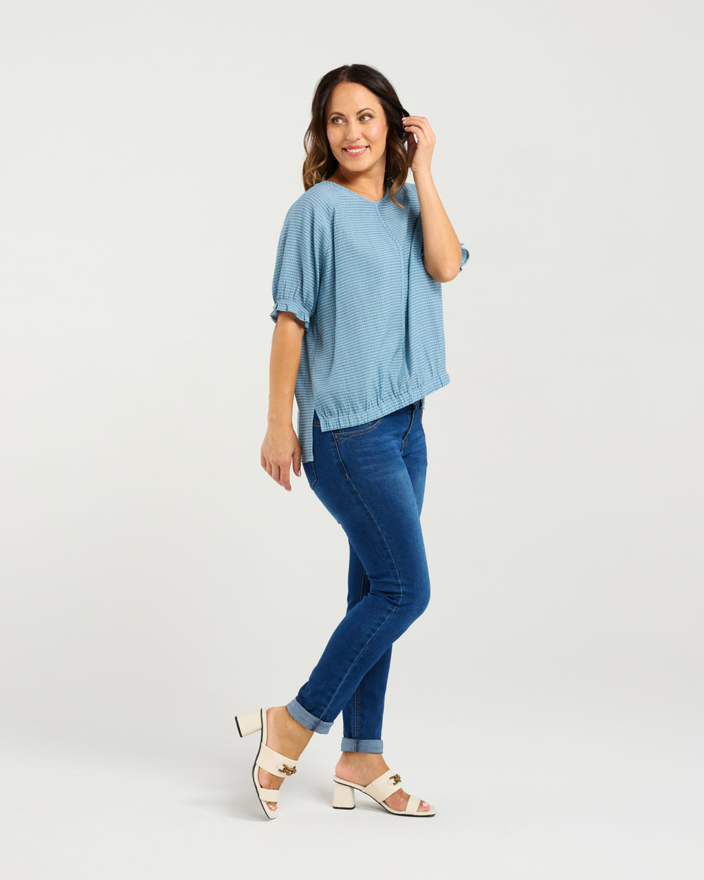 Woman wearing a blue top and jeans on a white background
Ella Top Blue