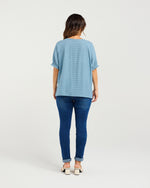 Woman wearing a light blue top and dark blue jeans on a white background
Ella Top Blue