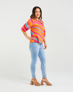 Woman wearing a colorful striped sweater and light blue jeans on a white background
Willow Top Dynamic Stripe