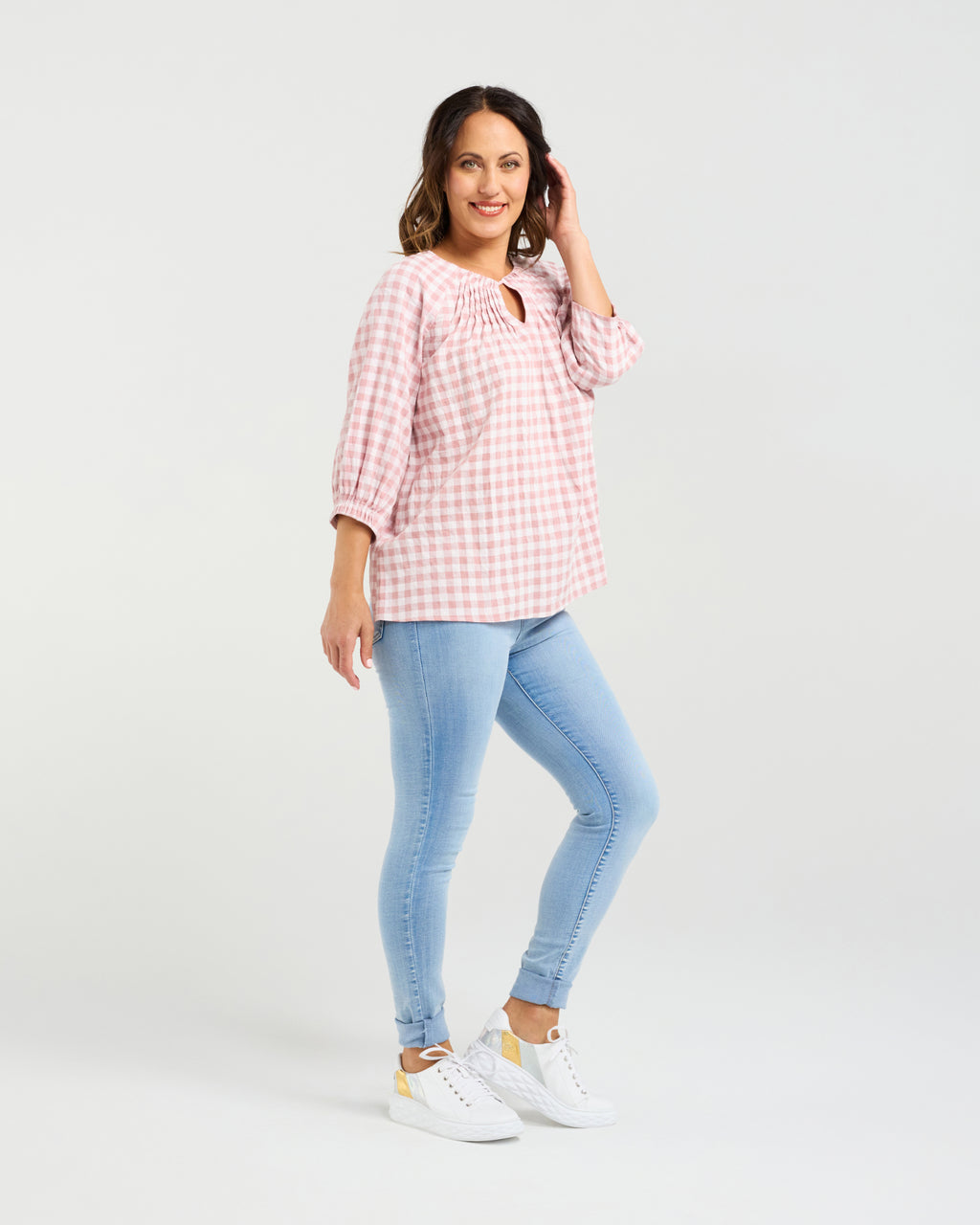 Woman wearing a pink checkered blouse and light blue jeans on a white background
Hazel Top Pink Check