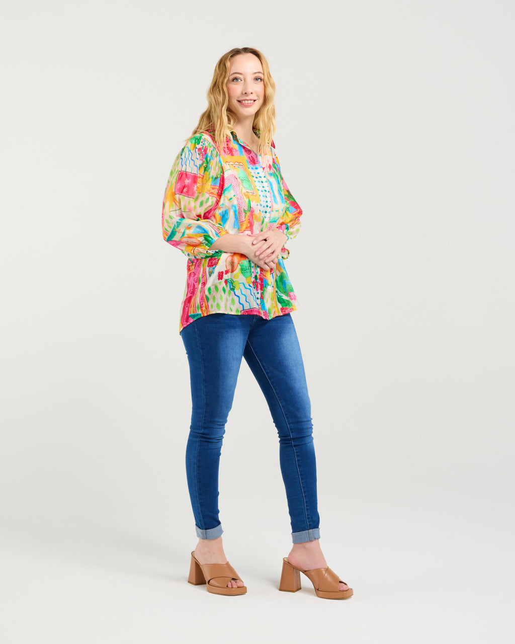 Woman wearing a colorful floral blouse and blue jeans on a white background
Emily Shirt Radiant