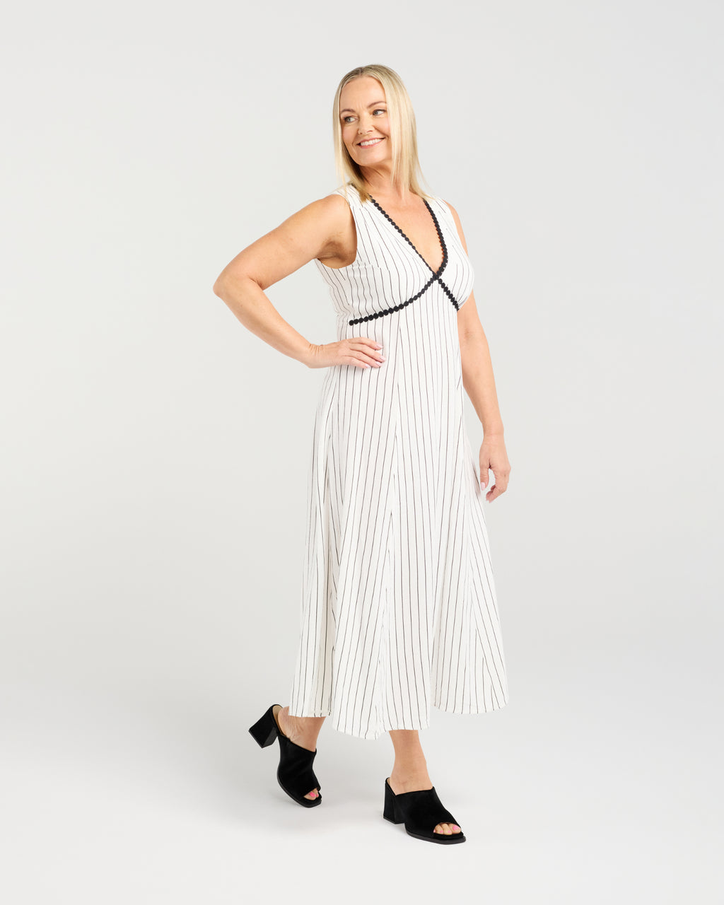 Woman wearing a white pleated dress with black trim on a white background
Zariah Dress Pinstripe