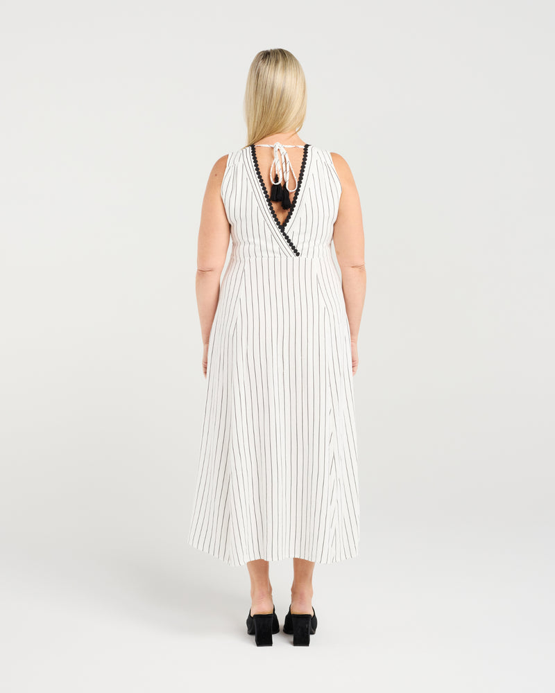 Woman wearing a white striped dress with black trim on a plain background
Zariah Dress Pinstripe