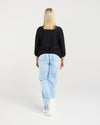 Woman wearing a black top and light blue jeans on a white background
Quinn Cardi Black