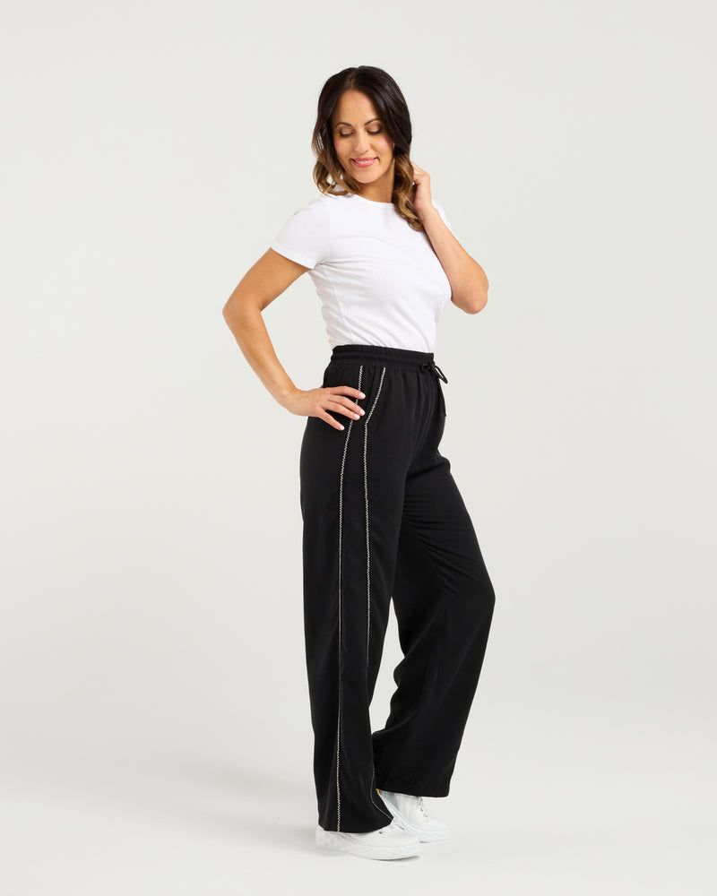 Woman wearing black high-waisted pants with white trim on a light gray background
Polly Pants Black
