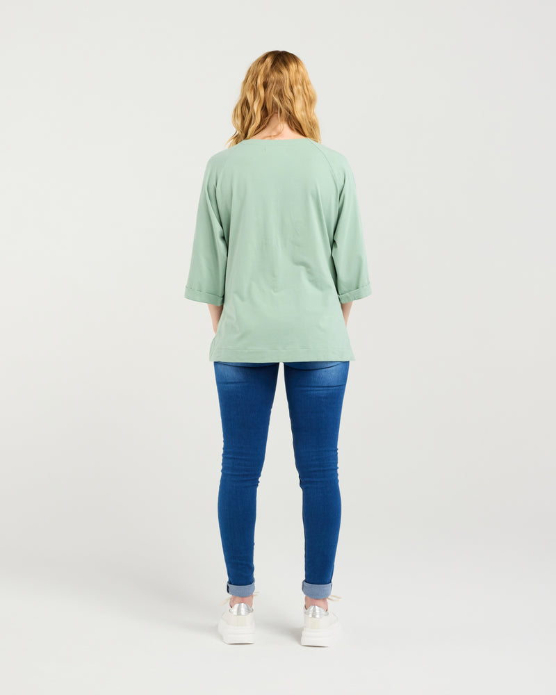 Person wearing a light green top and blue jeans on a white background
Kate T-Shirt Sage