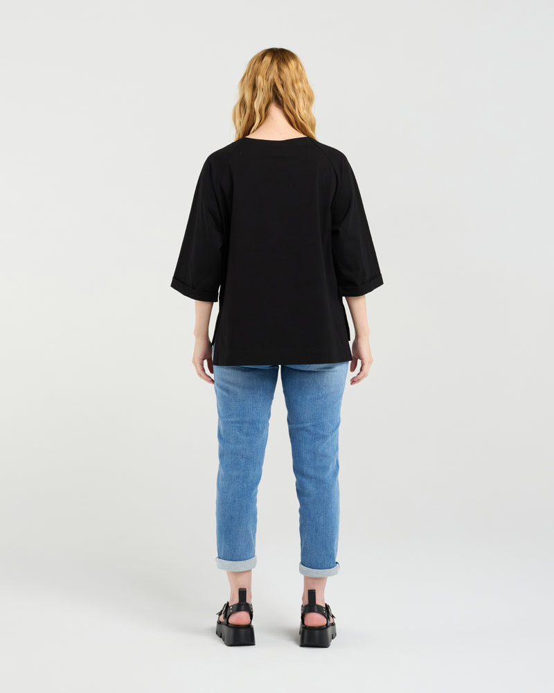 Person wearing a black t-shirt and blue jeans on a white background
Kate T-Shirt Black