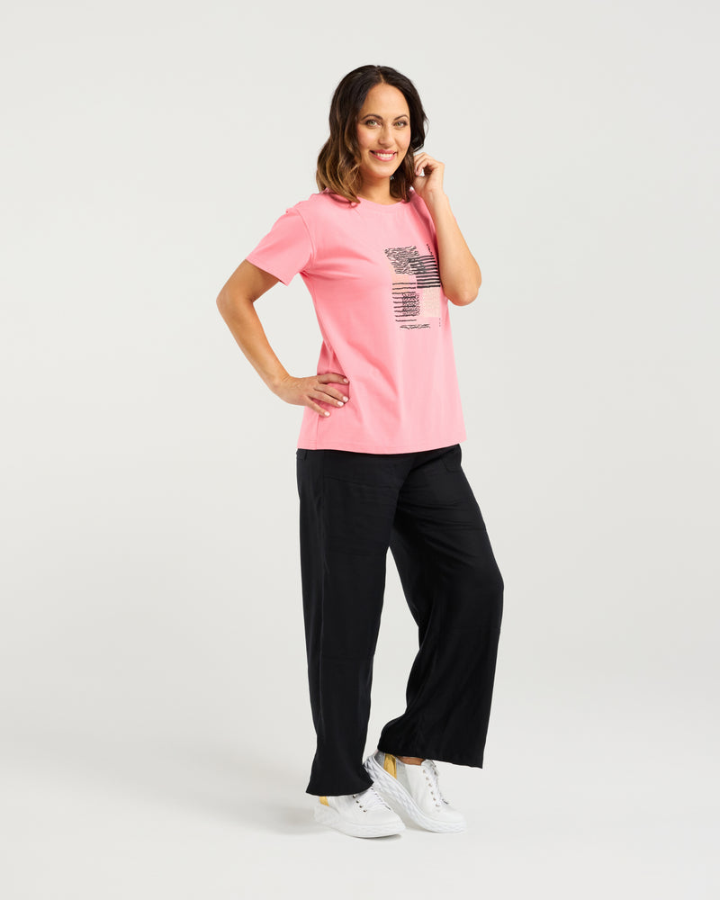 Woman wearing a pink t-shirt and black pants on a white background
Livia T-Shirt Pink