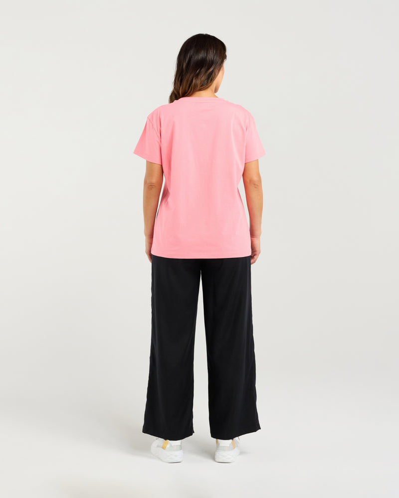 Person wearing a pink t-shirt and black pants on a white background
Livia T-Shirt Pink