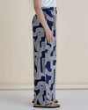 Person wearing navy blue pants with white geometric pattern on a beige background