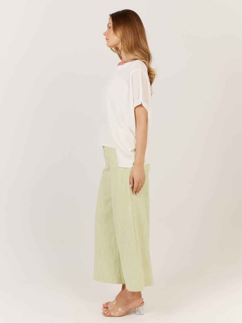Woman wearing a white top and light green pants on a plain background Corsica knit White