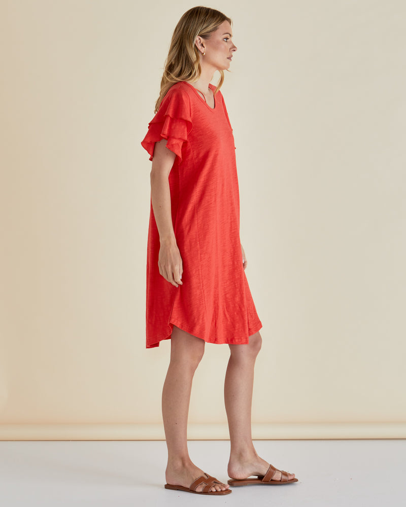 Woman wearing a red dress with ruffled sleeves against a beige background
Sydney Tee Dress Red
