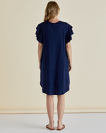 Woman wearing a navy blue dress with ruffled sleeves against a beige background
Sydney Tee Dress Navy